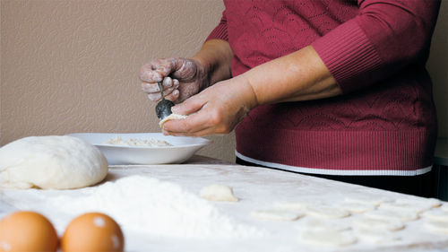 Midsection of woman preparing food at table