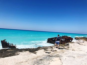 Scenic view of beach against clear blue sky