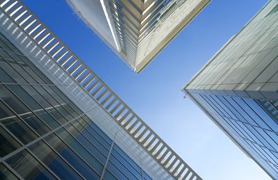 Low angle view of modern buildings against clear blue sky