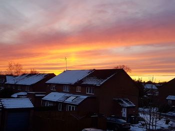 Houses in town against sky during sunset
