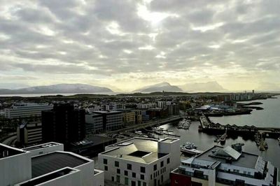 View of cityscape against cloudy sky