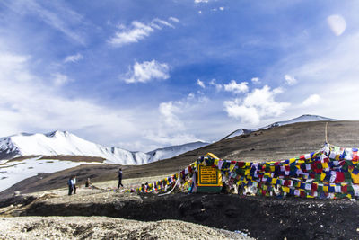 Group of people on mountain road against sky