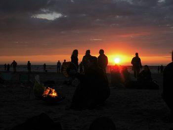 Silhouette people at beach during sunset