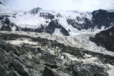 Alpine glacier on mount belukha, rocks, snow and stones