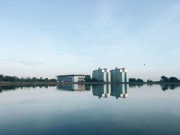 Reflection of buildings in lake against sky