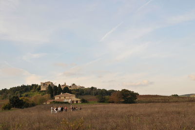 People on grassy landscape against sky