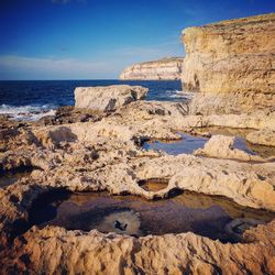 Scenic view of rocky beach against sky