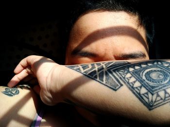 Close-up of young man with tattoo on hands