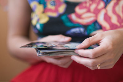 Midsection of woman holding photographs