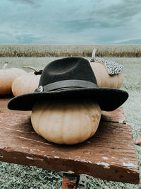 Cropped image of white pumpkin topped with fedora on table