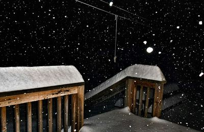 Snow covered walkway against sky at night