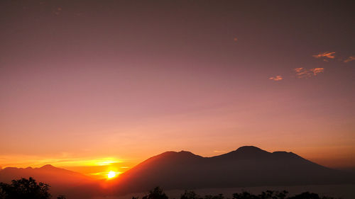 Scenic view of silhouette mountains against romantic sky at sunset