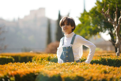 Woman standing amidst plants on field against sky