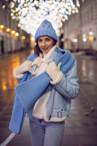 A woman in blue clothes walks along an empty street at night in moscow in winter