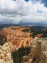 Aerial view of rock formations against cloudy sky