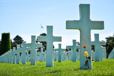 View of cross in cemetery against sky