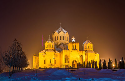 Illuminated building against sky during winter at night