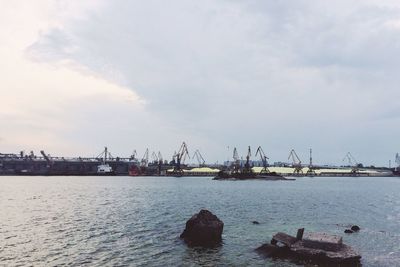 View of harbor against cloudy sky