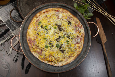 Brazilian portuguese-style pizza with ham, egg, pepper, onion, mozzarella, top view