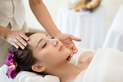 Cropped image of masseur massaging young woman on table