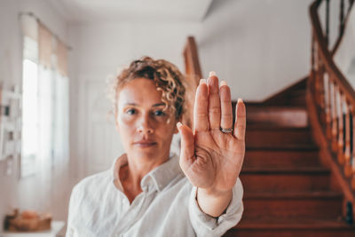 Portrait of woman gesturing at home