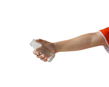 Close-up of hand holding bottle against white background