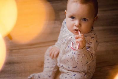 Christmas portrait of a beautiful little child holding a candy cane