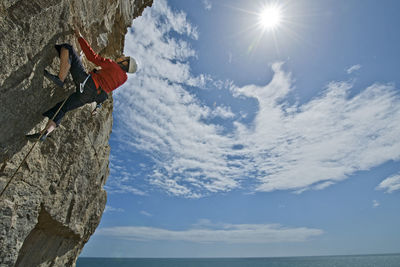 Woman climbing on limestone cliff near the coast of swanage / uk