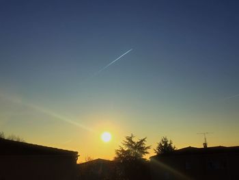 Low angle view of vapor trails in sky during sunset