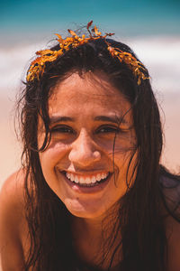 Woman in the foreground smiling with the sea in the background