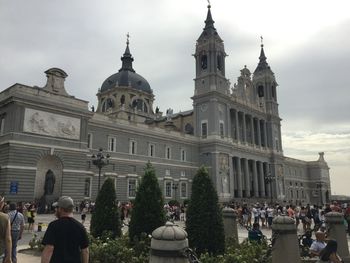 People at cathedral against sky