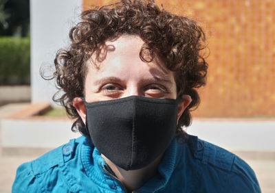 Brazilian curly hair woman using mask on a sunny day.