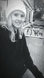 Portrait of smiling girl sitting outdoors