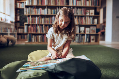 Student doing puzzle and reading book in school library. primary school student. curious child