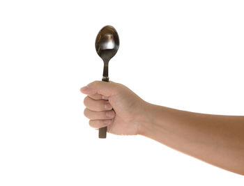 Close-up of hand holding lamp against white background