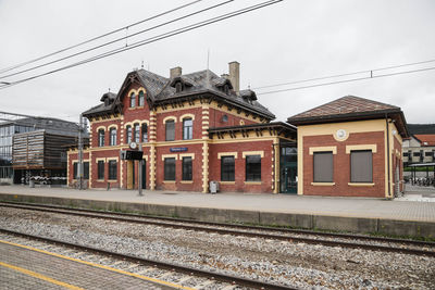 Railroad tracks by buildings in city against sky