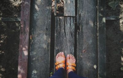 Low section of woman standing on wooden floor