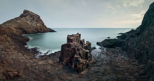 Rocks on beach against sky