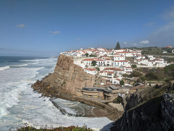 Buildings by sea against sky in city