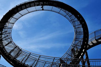 Low angle view of ferris wheel against blue sky