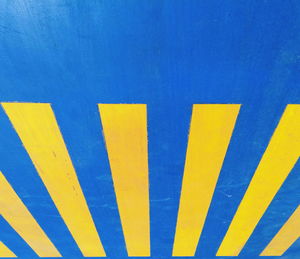 Full frame shot of yellow and blue sign on wall