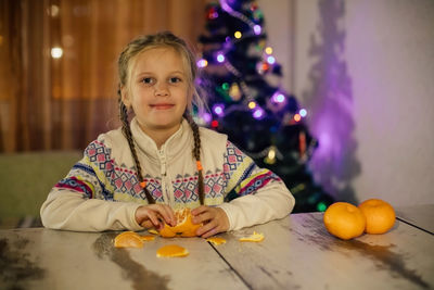 Portrait of a girl with christmas lights on table