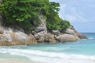 Scenic view of rocks on beach against sky