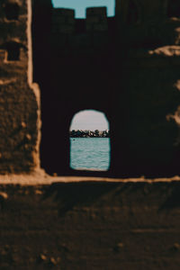 Sea seen through hole in wall