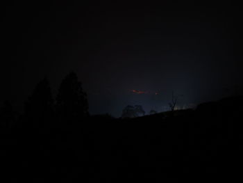 Low angle view of silhouette trees against sky at night