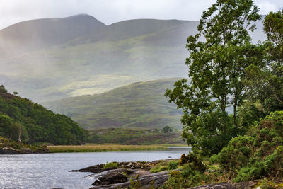 Scenic view of river and mountains against sky