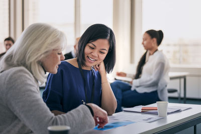 Smiling women sitting together in class