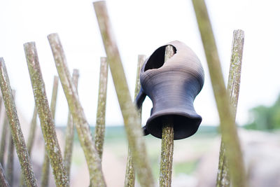 Close-up of earthen jug in wooden post