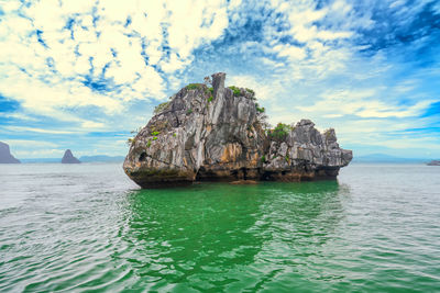 Rock formation in sea against sky