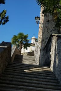 Low angle view of steps amidst trees against clear sky